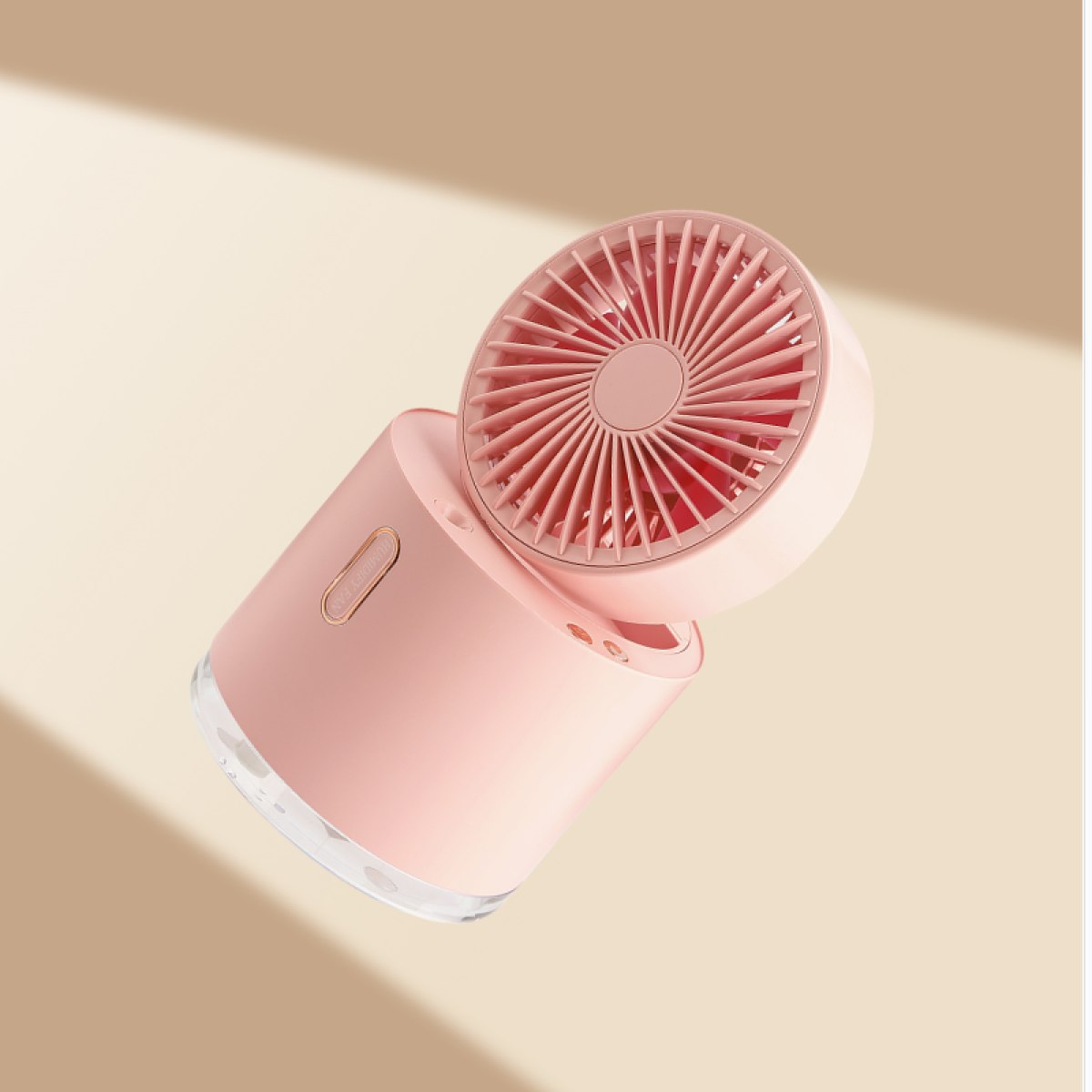 Un ventilador portátil rosa y blanco. El cabezal del ventilador está inclinado y tiene un diseño circular. La base es cilíndrica con fondo transparente.