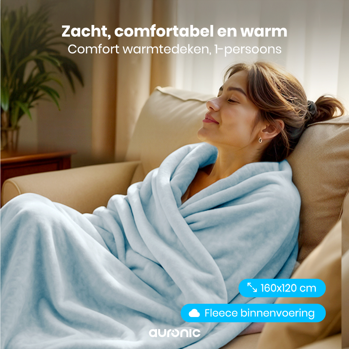 A woman wrapped in a light blue blanket sits on a beige couch. The blanket has a fleece lining. Text says 'Soft, comfortable and warm'.