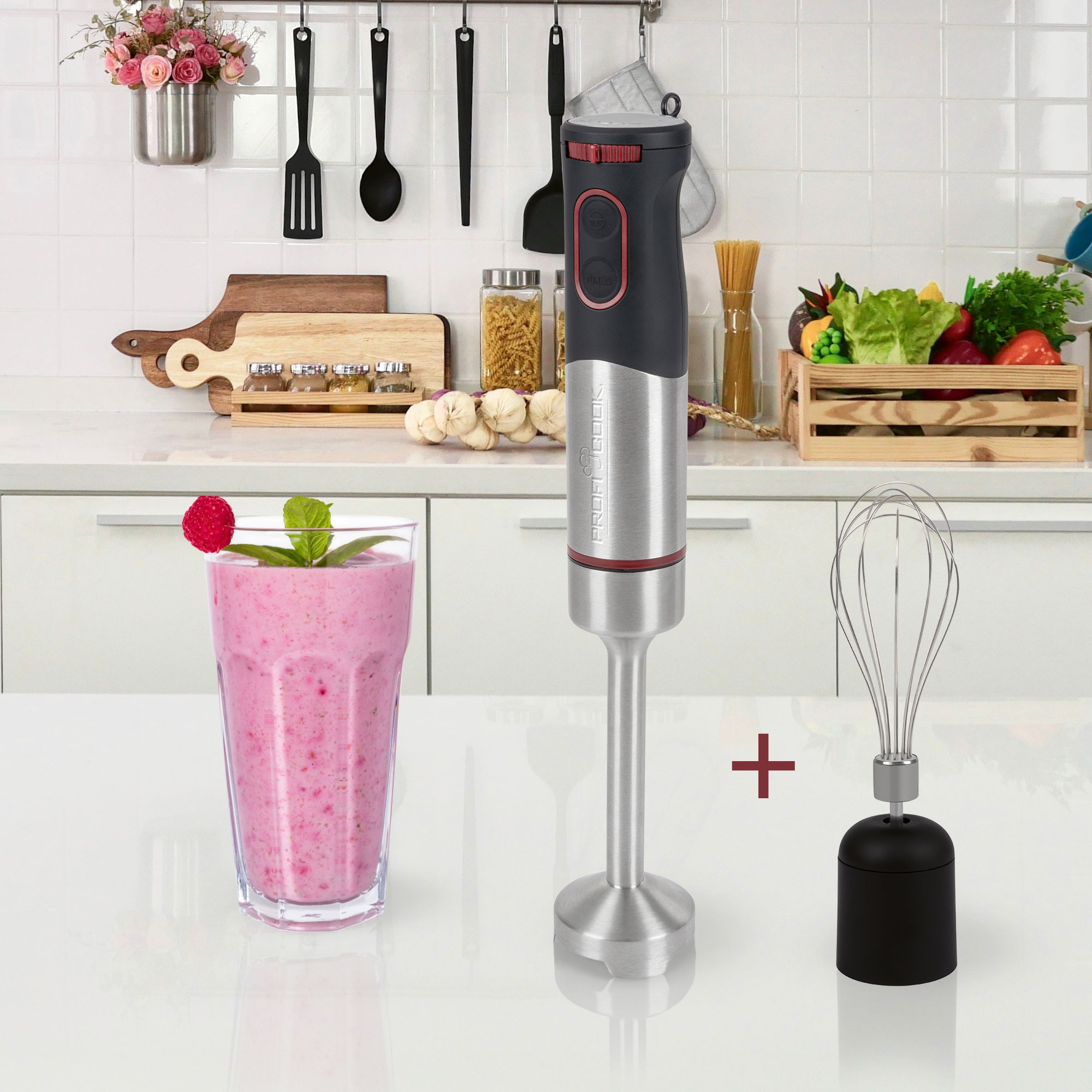 Blender, szklanka różowego smoothie z maliną i miętą oraz trzepaczka znajdują się na białym stole.