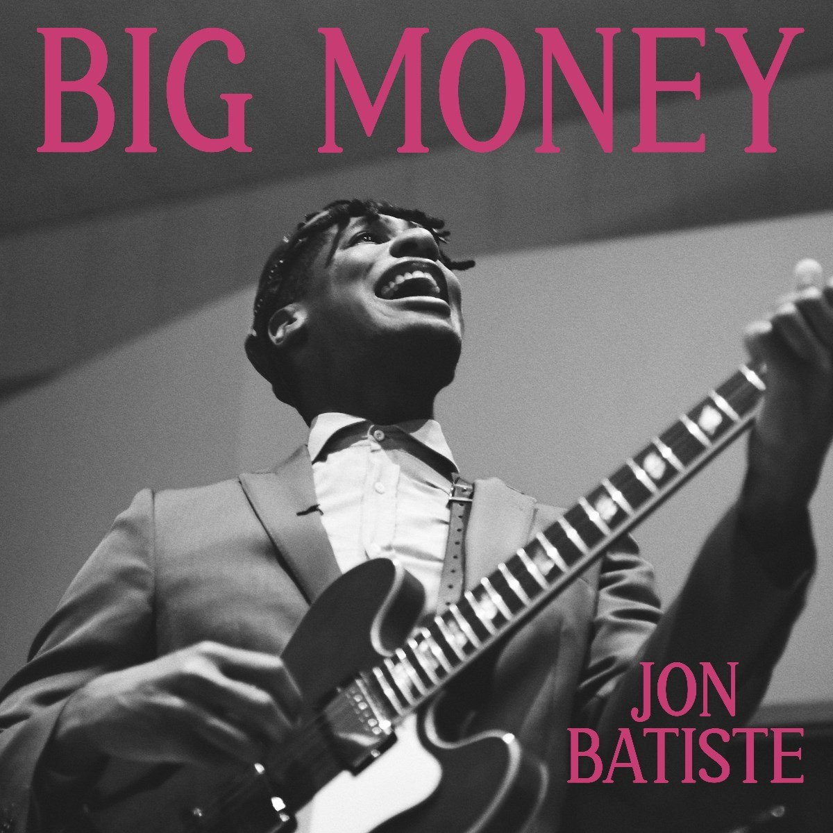 Foto in bianco e nero. Un uomo suona la chitarra, guardando in alto. Il testo recita 'BIG MONEY' e 'JON BATISTE'.