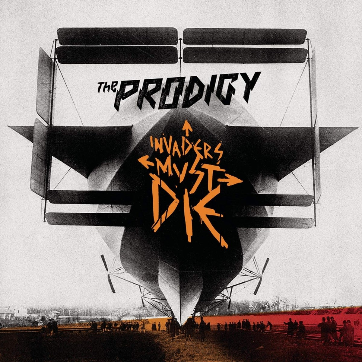 Copertina dell'album. Un dirigibile con testo 'The Prodigy' e 'Invaders Must Die'. Persone in piedi in primo piano.