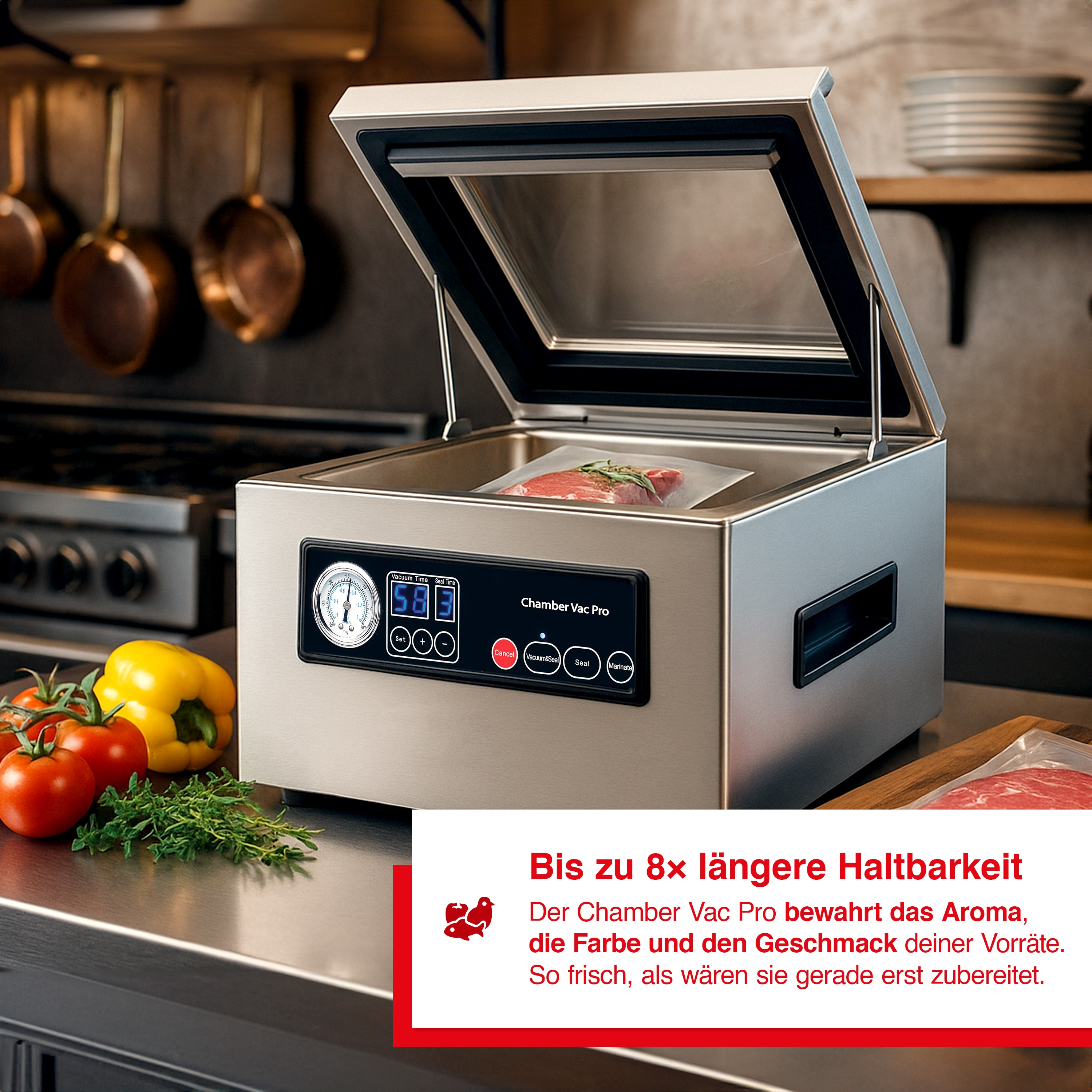 Ein Vakuumierer mit Fleisch. Tomaten, Paprika und Kräuter liegen auf der Theke. Kupferpfannen hängen im Hintergrund.