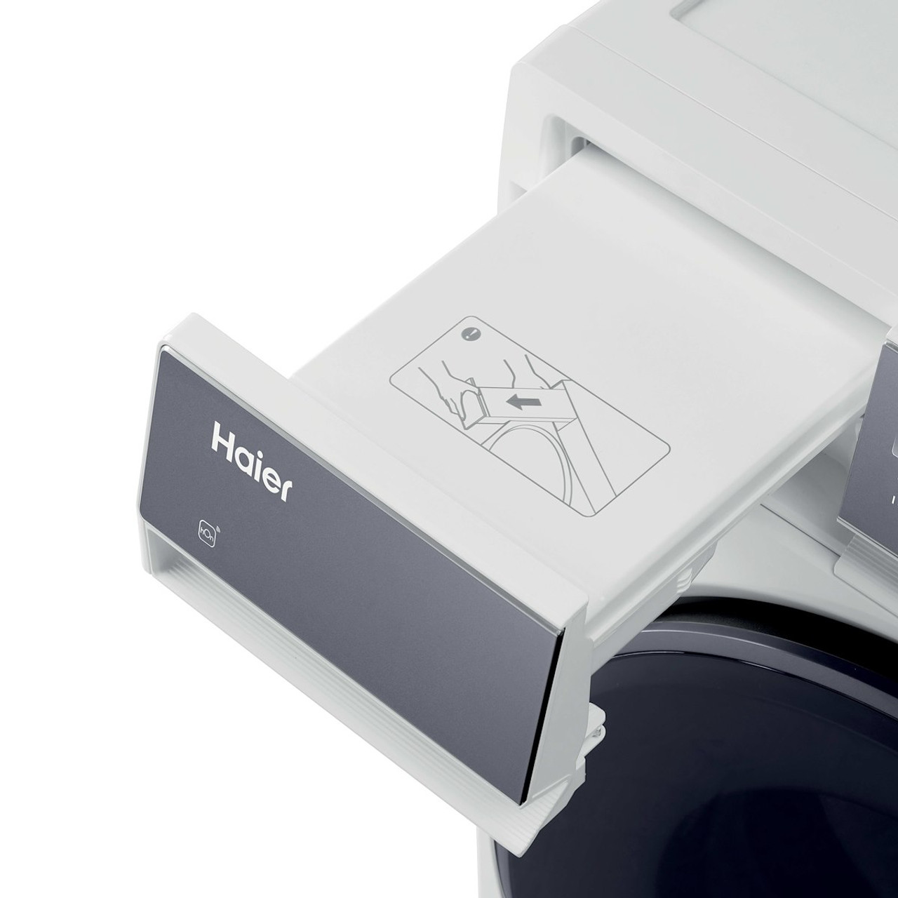 Primo piano del cassetto del detersivo di una lavatrice Haier, bianco e grigio scuro. Un diagramma mostra come aggiungere il detersivo.