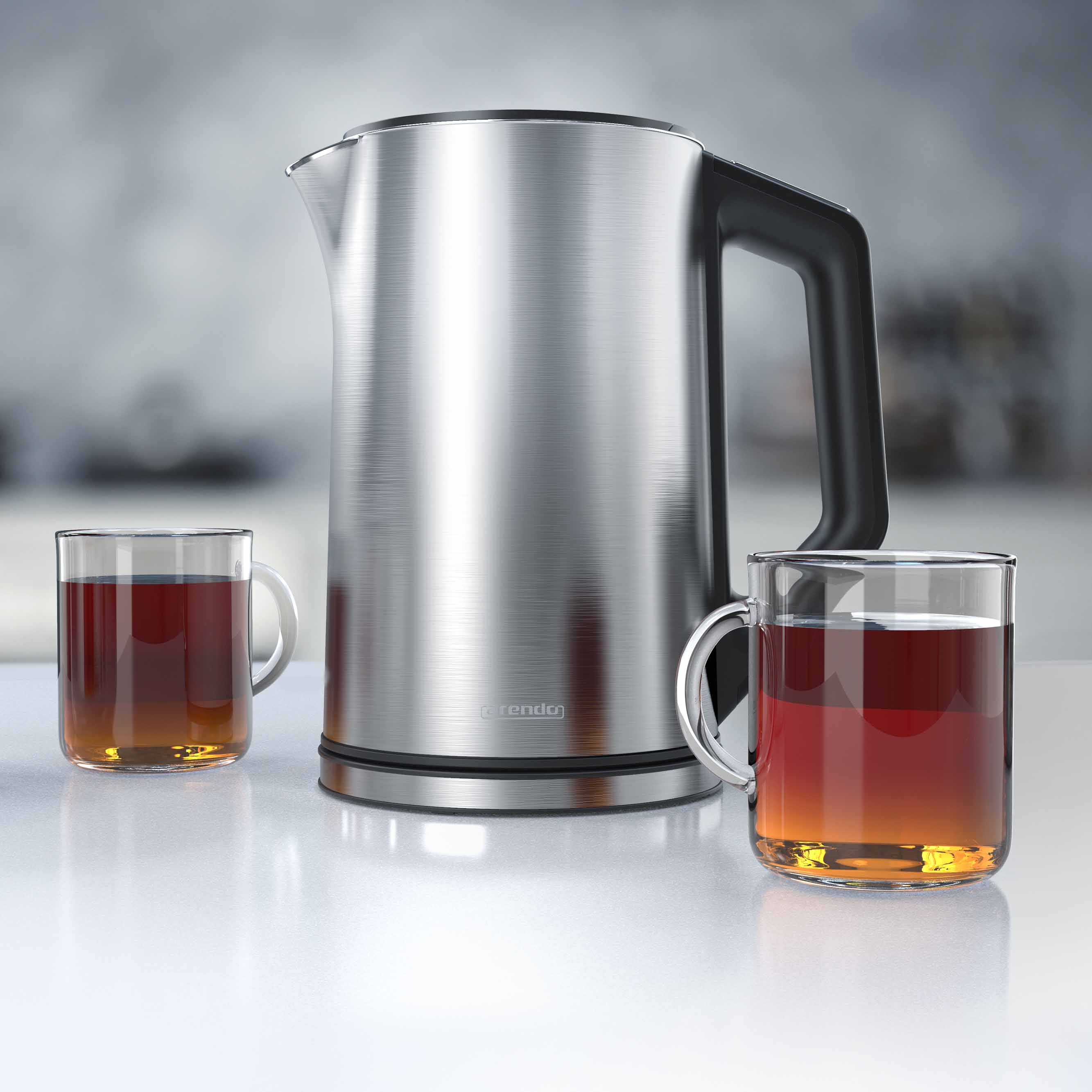 Ein metallischer Wasserkocher und zwei Glasbecher mit Tee stehen auf einer weißen Oberfläche. Der Hintergrund ist unscharf.