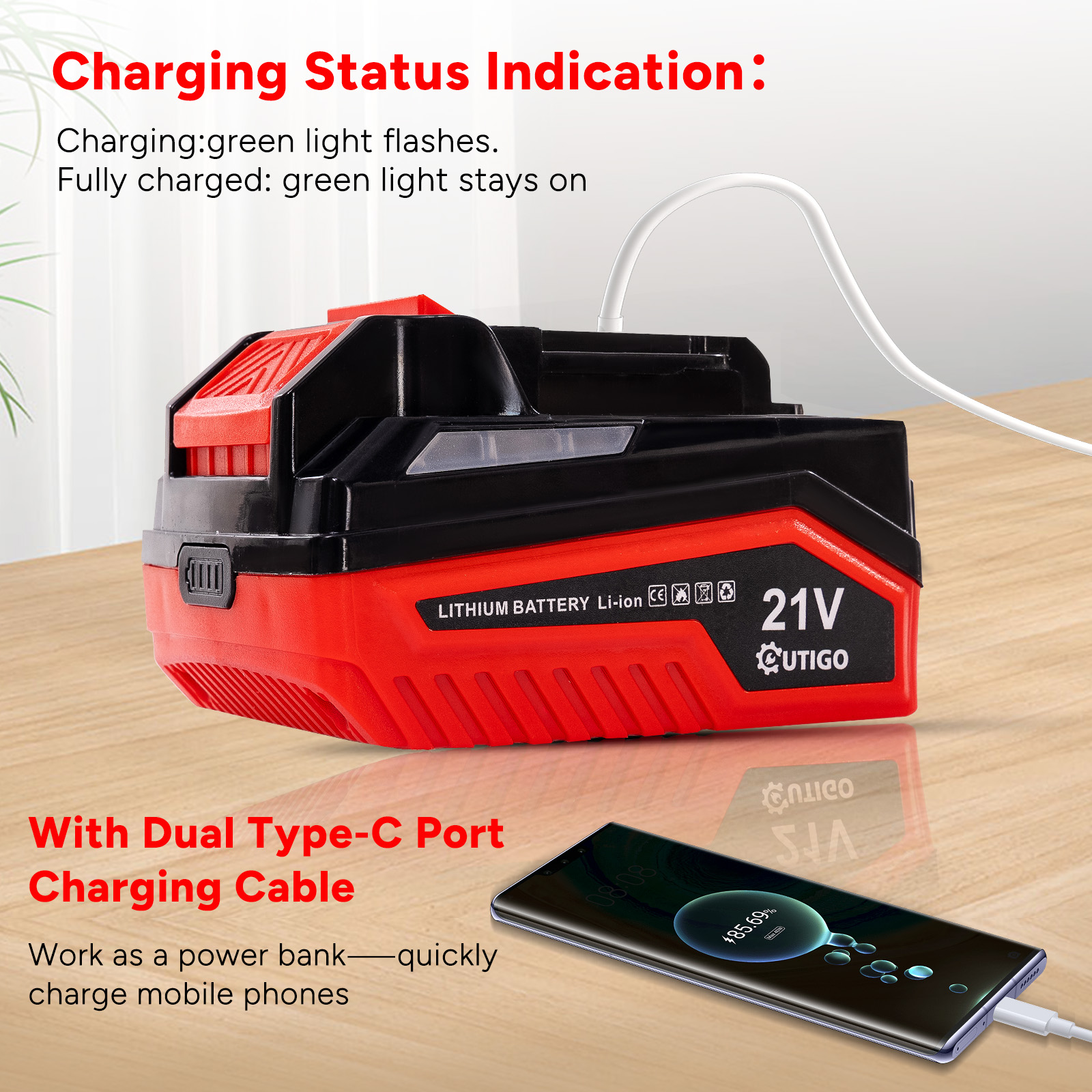 Czerwono-czarny pakiet baterii z białym kablem ładującym. Telefon ładuje się na drewnianym stole.