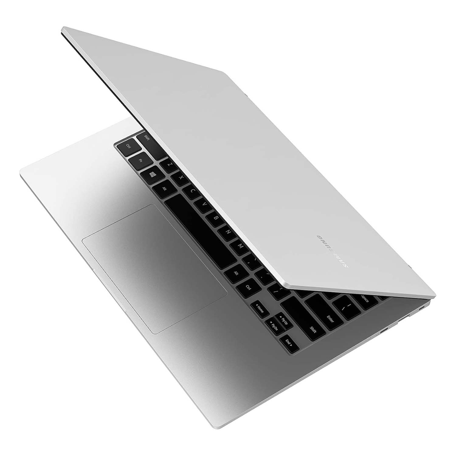 Una computadora portátil plateada está ligeramente abierta, mostrando el teclado. La pantalla está levantada. La marca 'Samsung' es visible.