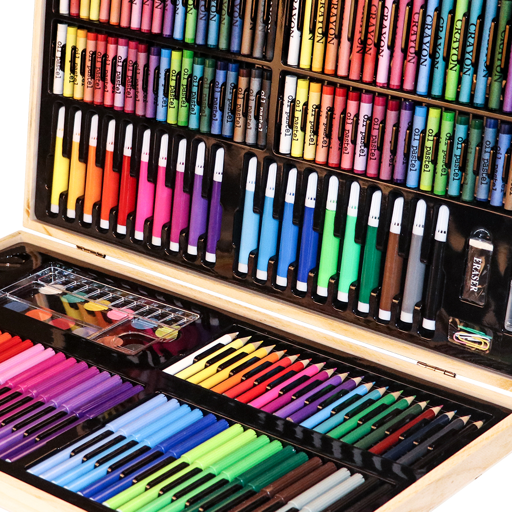 Kit de arte de madera abierto lleno de crayones coloridos, pasteles al óleo y lápices, ordenados en compartimentos.