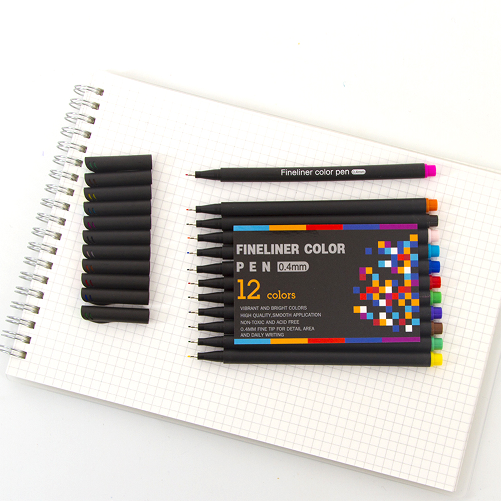 Un juego de 12 rotuladores finos negros con puntas de colores y un bolígrafo individual sobre papel cuadriculado.