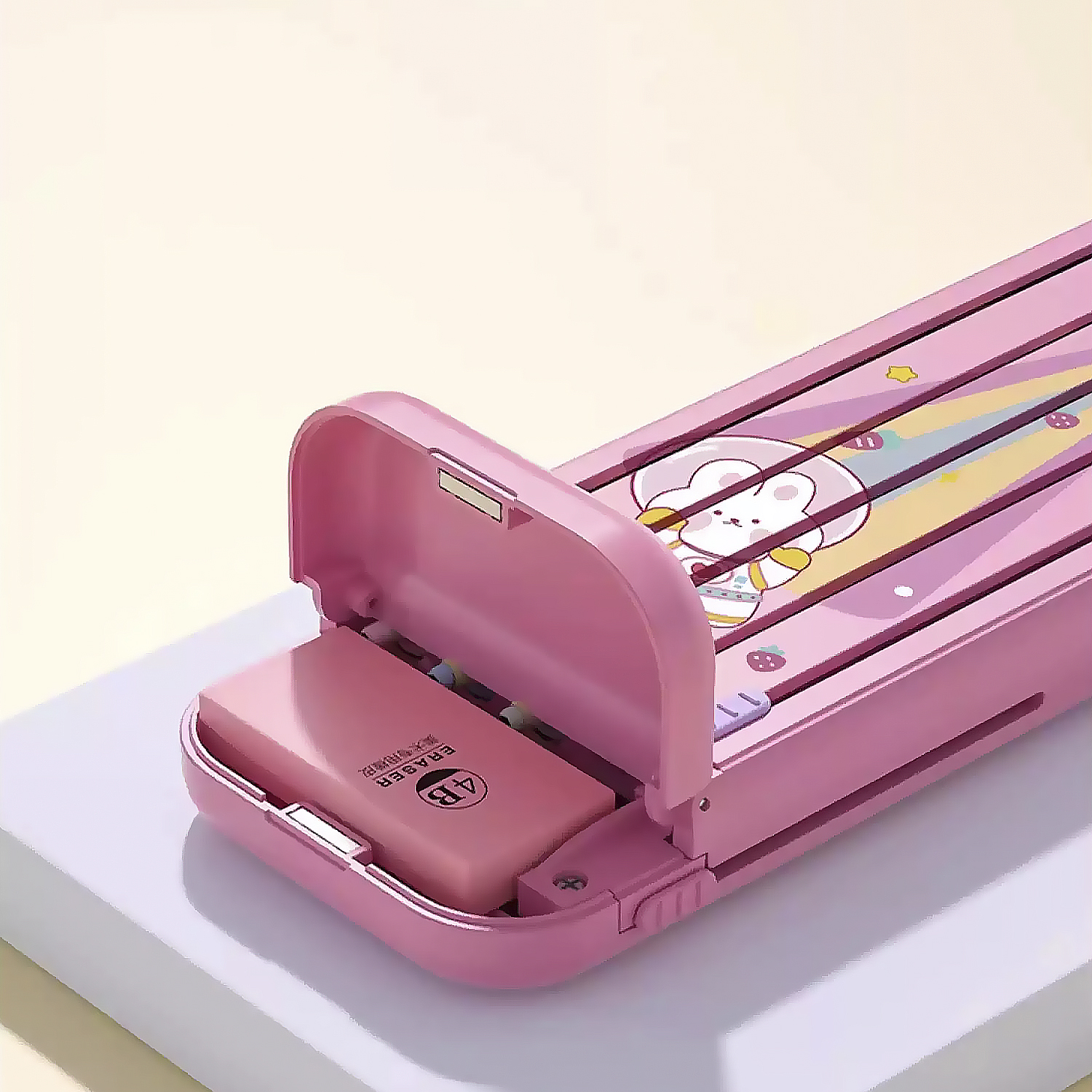 Un estuche rosa con un diseño de conejito de dibujos animados, abierto para revelar un borrador. El estuche está sobre una superficie blanca.