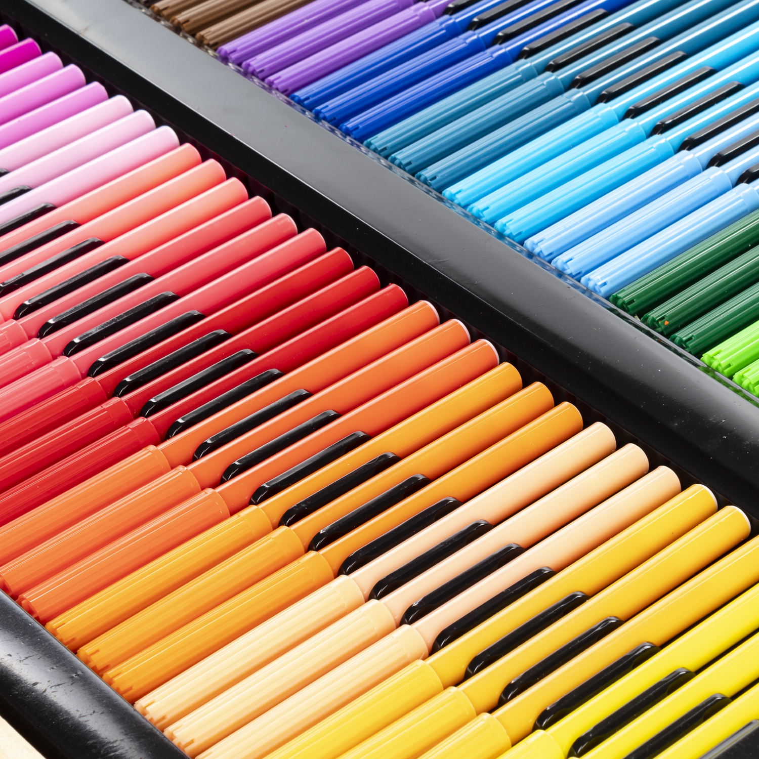 Primer plano de una caja llena de rotuladores de colores. Se ven rotuladores en tonos rosa, naranja, amarillo, verde, azul y morado.