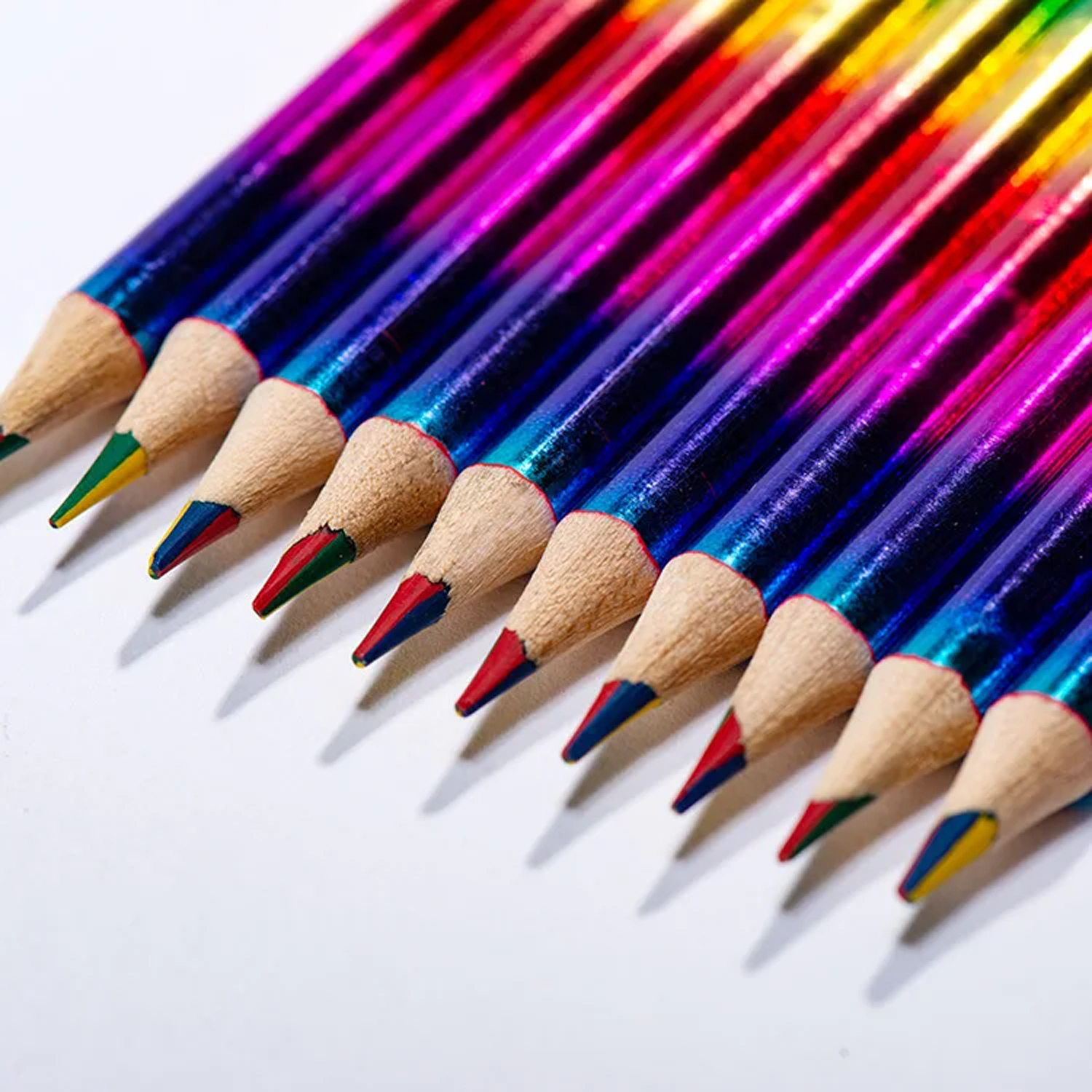 Primer plano de lápices de colores dispuestos en diagonal. Lápices con puntas de colores y barriles azules.