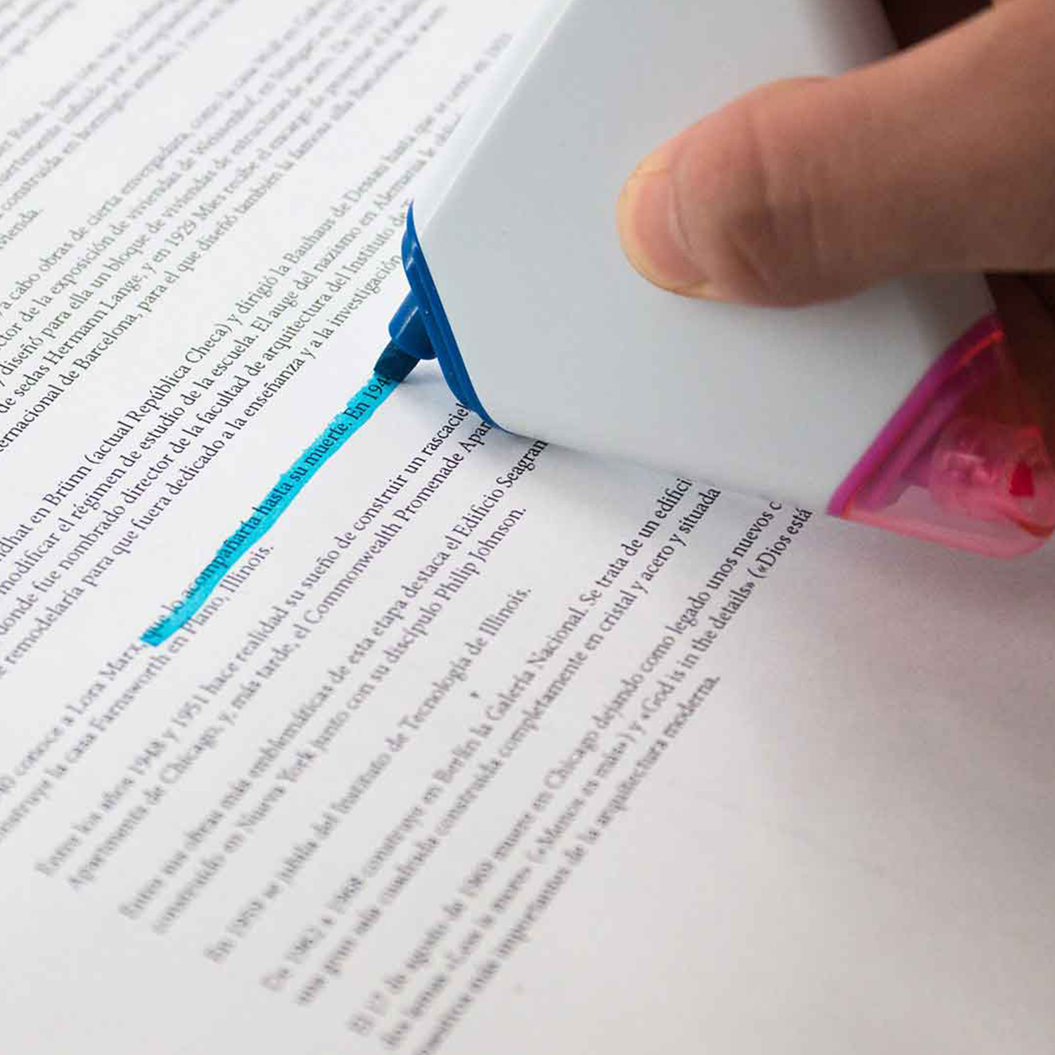 Una mano resalta texto en una página con un resaltador azul. El texto está en español.