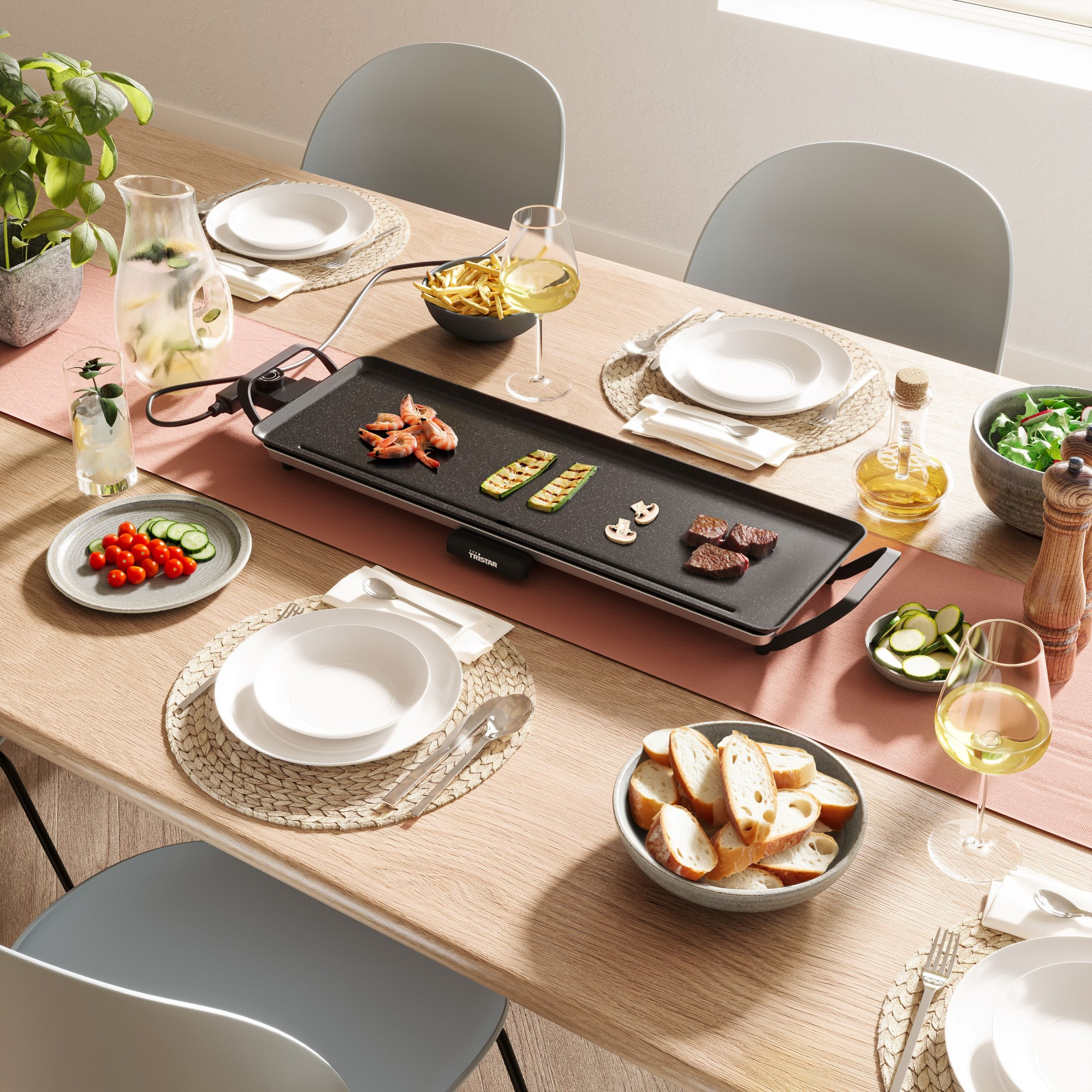 Ein Esstisch, der für eine Mahlzeit gedeckt ist. Enthält einen Grill mit Essen, Teller, Gläser, Gemüse, Brot und Getränke.