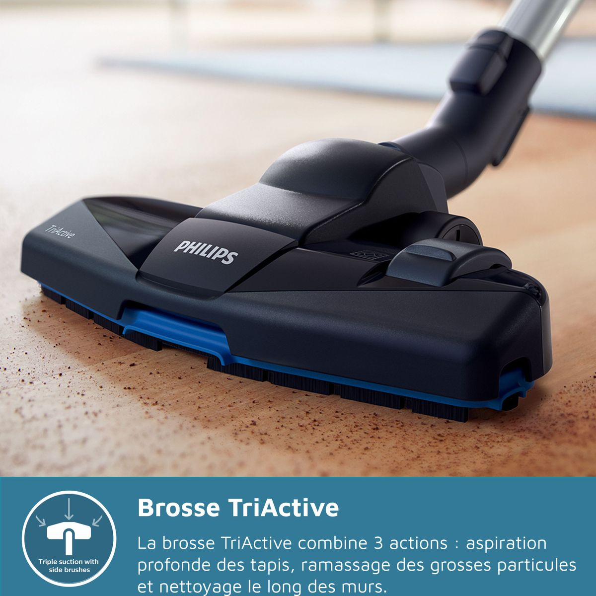Zbliżenie czarno-niebieskiej głowicy odkurzacza Philips TriActive na drewnianej podłodze. Widoczna nazwa marki.