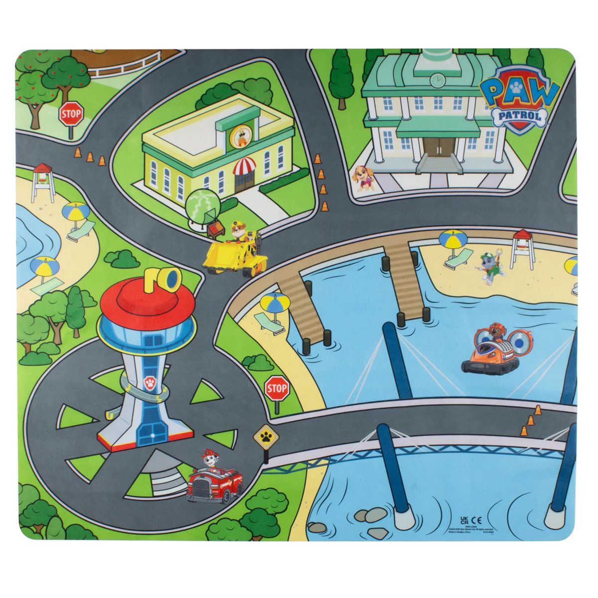 Un tapete de juego de Paw Patrol. Cuenta con edificios, carreteras, agua y personajes. Incluye un camión de bomberos rojo, una excavadora amarilla y una lancha.