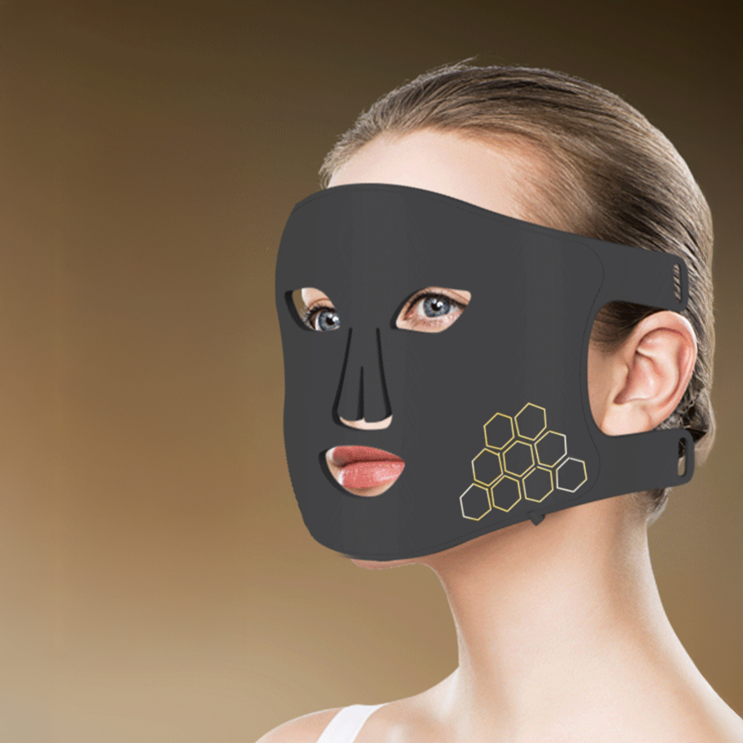 Eine Frau trägt eine schwarze Gesichtsmaske mit Wabenmuster. Die Maske bedeckt Augen, Nase und Mund. Der Hintergrund ist verschwommen.