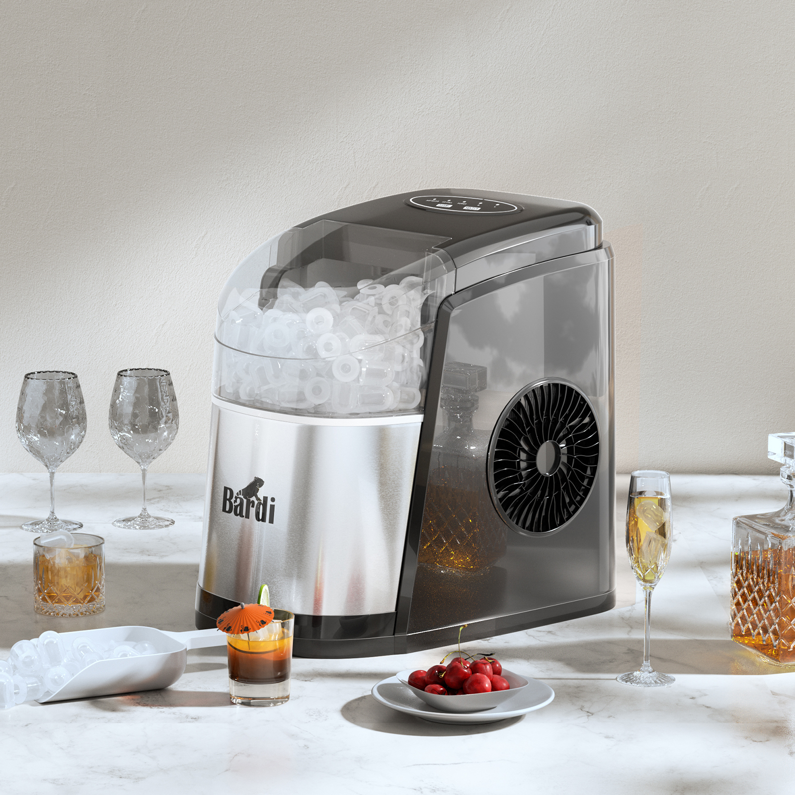 An ice maker, glasses, a cocktail, cherries, and a decanter are arranged on a marble surface. The ice maker is the focal point.