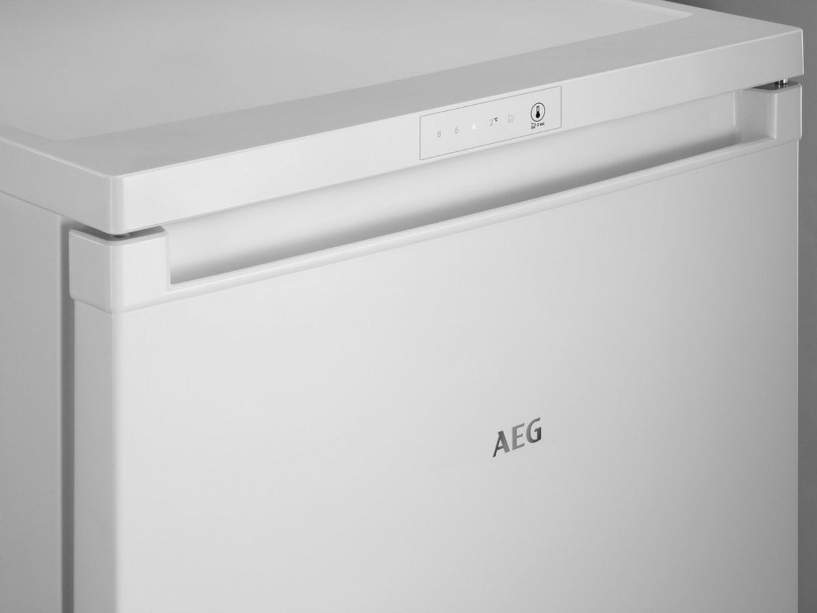 A white AEG chest freezer. It has a handle, control panel, and the AEG logo on the front. Background is plain.