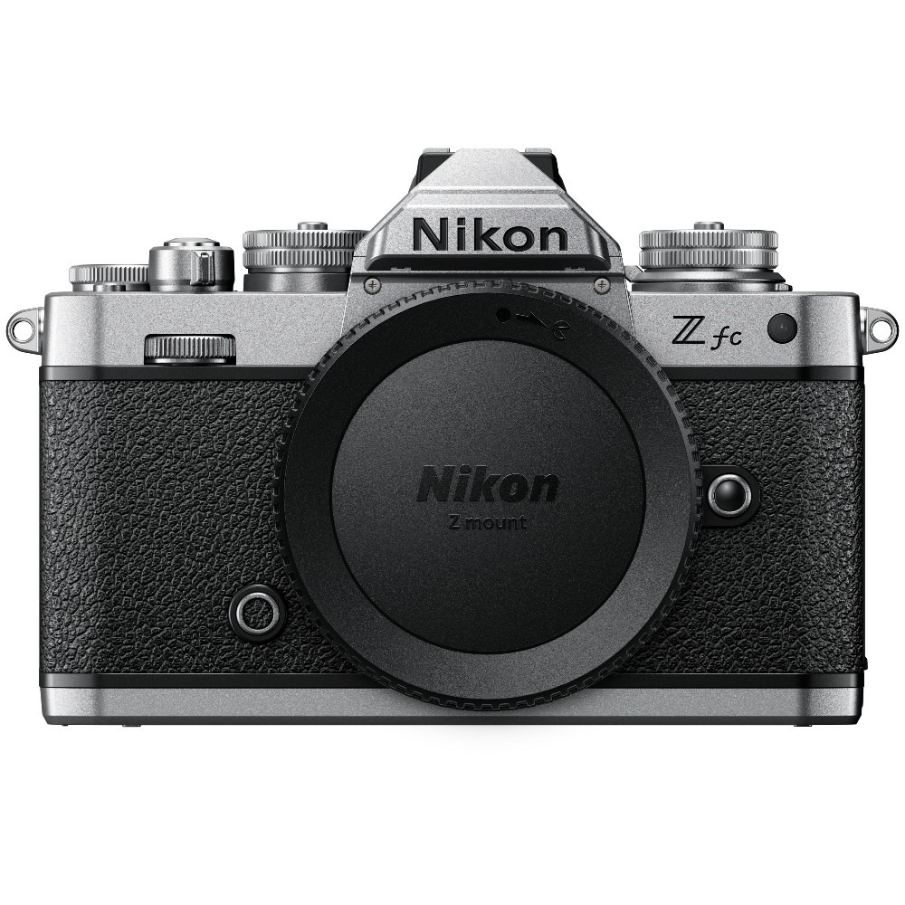 Een zilver-zwarte Nikon Z fc camera. De lens is bedekt. Hij heeft draaiknoppen en knoppen, met het Nikon logo prominent aanwezig.