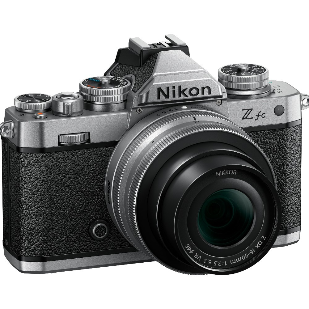 Een zilveren en zwarte Nikon Z fc camera met een lens bevestigd, schuin naar rechts. Op de lens staat 'NIKKOR'.