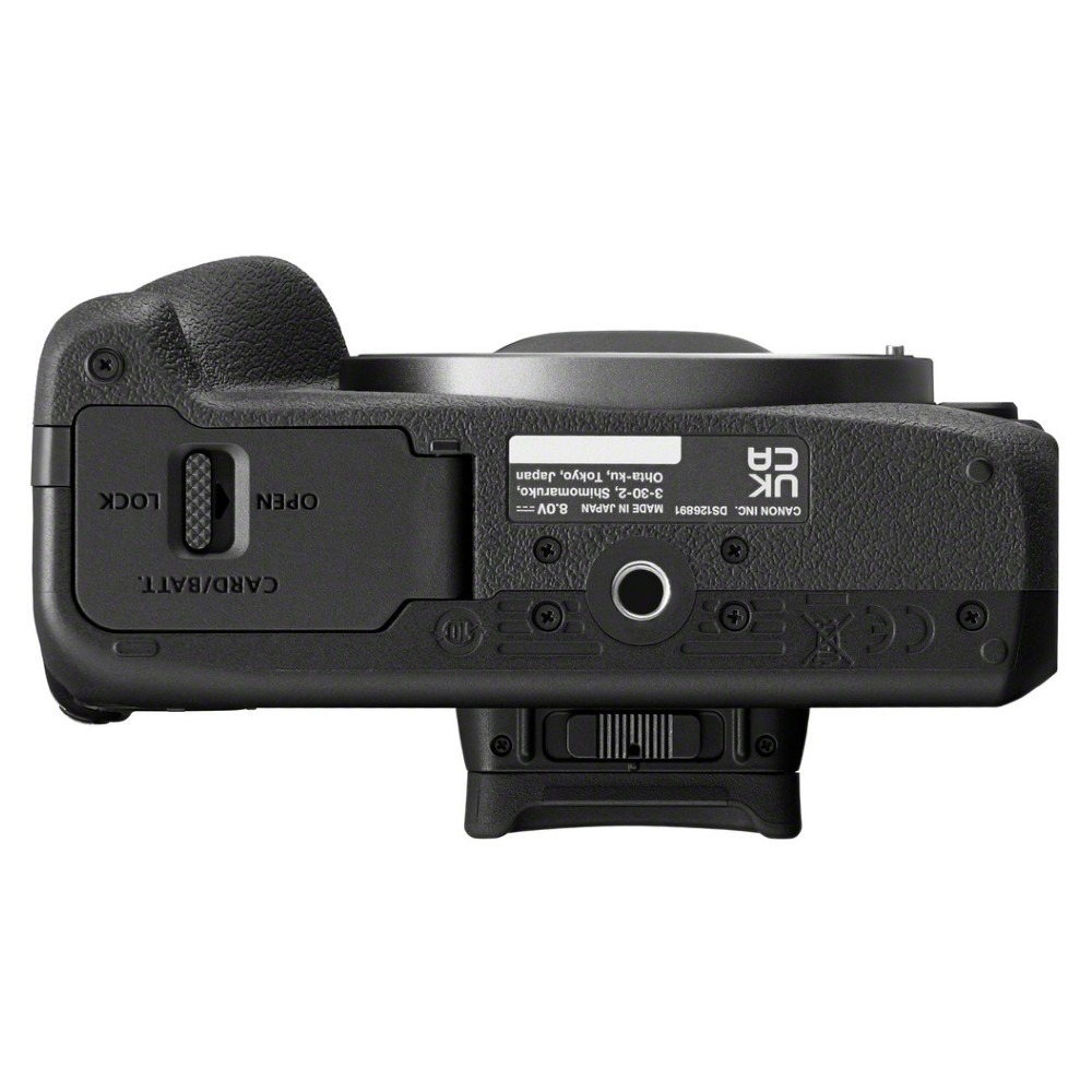 Black camera bottom view. Shows battery/card slot, various labels, and a grip. Made in Japan.