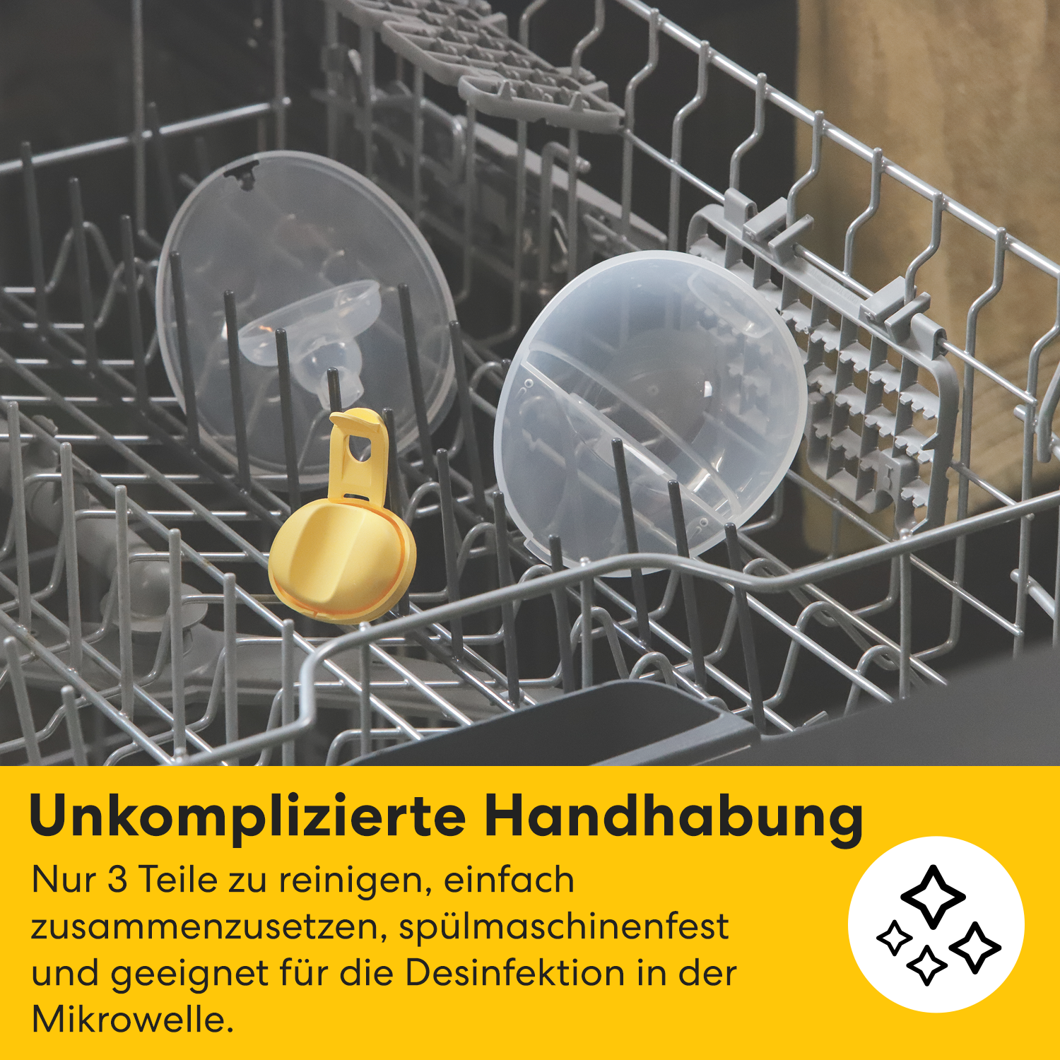 Geschirrspüler mit Brustpumpenteilen. Gelbes Objekt im Vordergrund. Transparente Kunststoffteile und Metallgestelle.