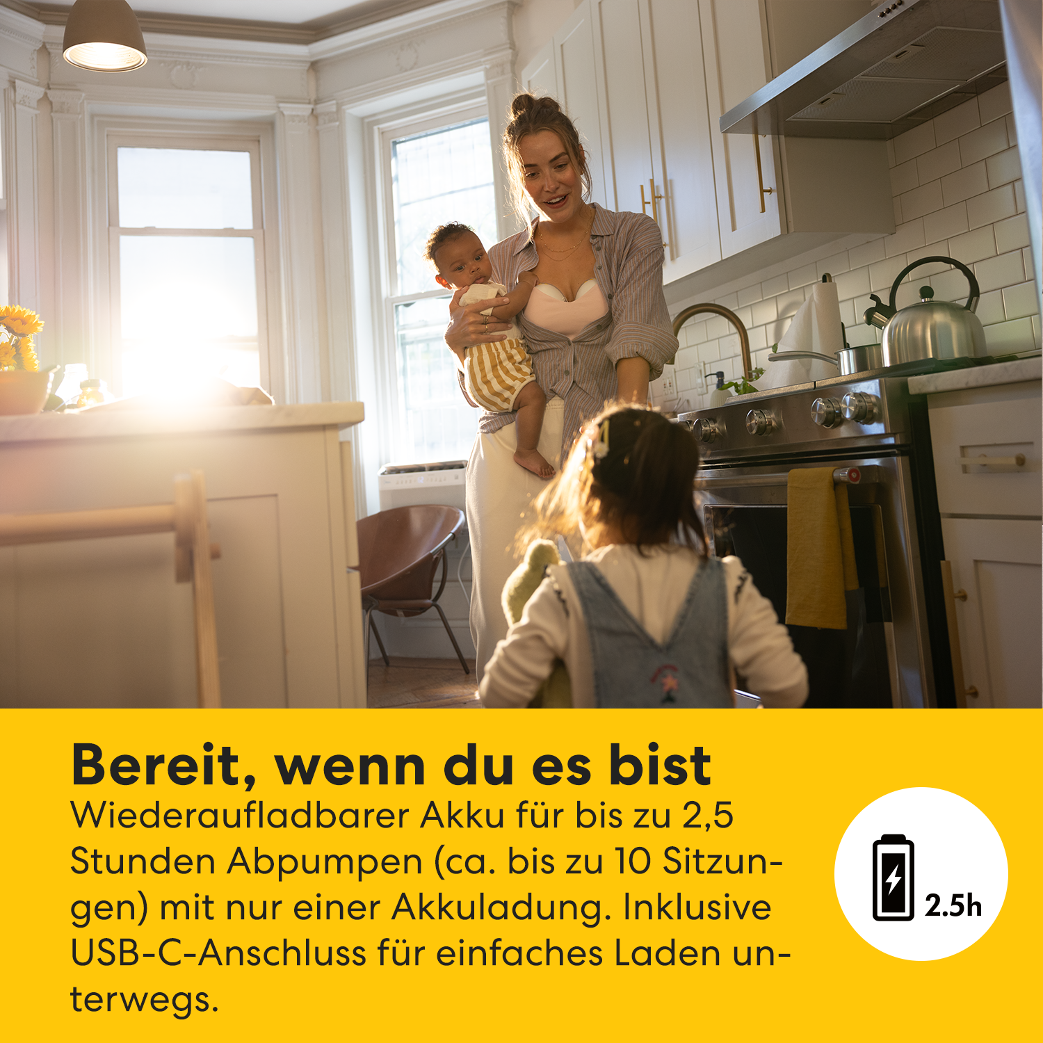 Eine Frau hält ein Baby in einer Küche, ein Kleinkind im Vordergrund. Text: Wiederaufladbarer Akku für bis zu 2,5 Stunden.