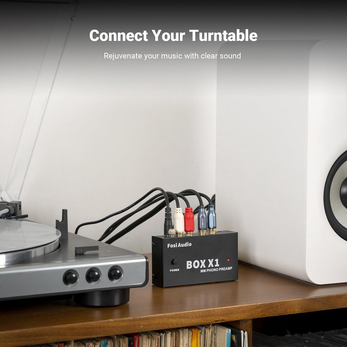 Gramofon podłączony do czarnej skrzynki przedwzmacniacza z napisem 'BOX X1'. Przewody z kolorowymi końcówkami łączą się ze skrzynką.