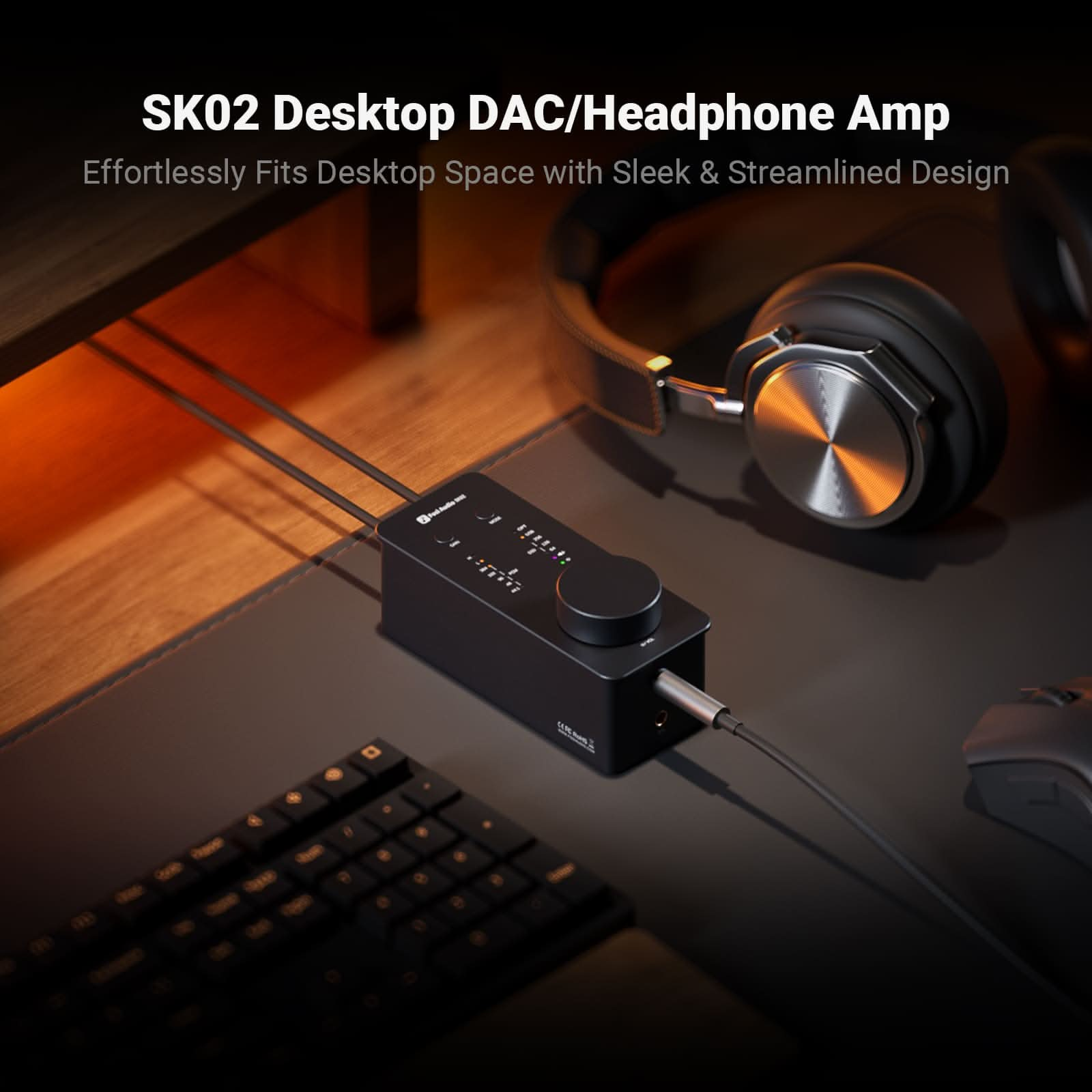 Schwarzer DAC/Kopfhörer-Verstärker auf dem Schreibtisch, mit Kopfhörern verbunden. Tastatur und Maus im Vordergrund. Schlankes Design.