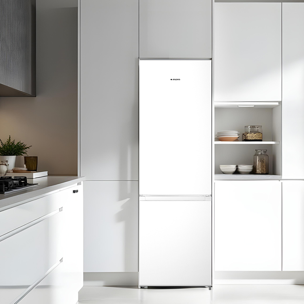 Una cocina blanca moderna con un refrigerador como punto focal. Se ven estantes con platos. También hay plantas y una encimera.
