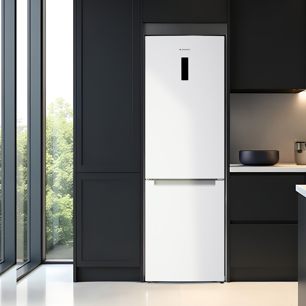 Un refrigerador blanco se encuentra entre gabinetes negros y una ventana grande. Un tazón y electrodomésticos están en la encimera.