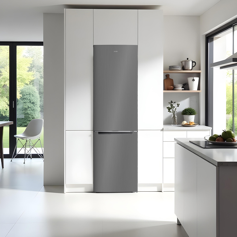 Una cocina moderna con nevera gris, armarios blancos y ventana. Frutas en la encimera. La habitación es luminosa y limpia.