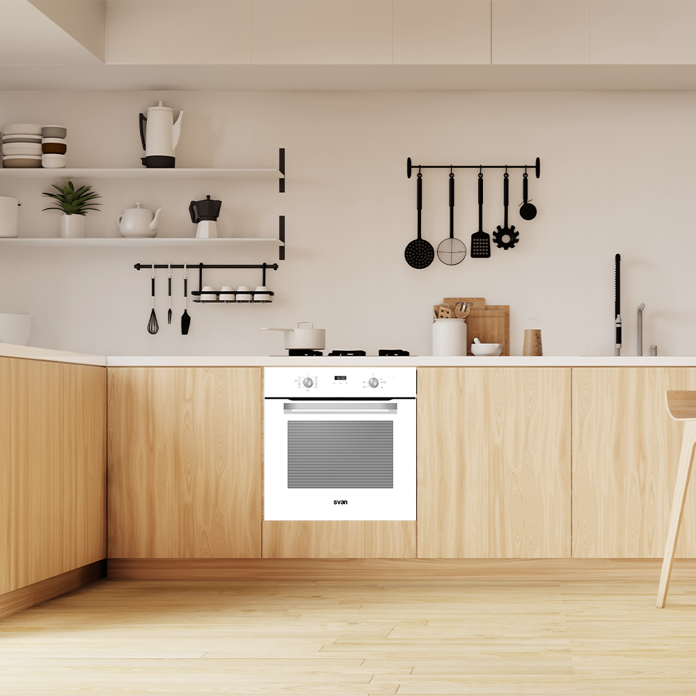 Una cocina moderna con horno blanco, gabinetes de madera y varios utensilios de cocina colgados en la pared. El suelo es de madera.