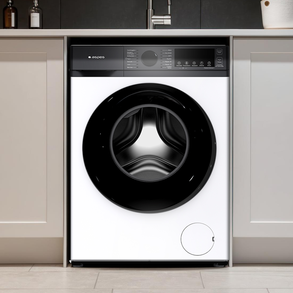 Biała pralka z czarnymi drzwiami i panelem sterowania jest umieszczona w białej szafce. Tłem jest kuchnia.