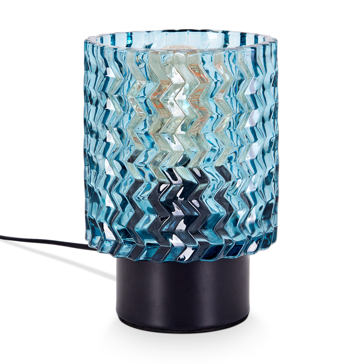Eine blaue Glaslampe mit Zickzackmuster steht auf einem schwarzen Sockel. Ein schwarzes Kabel geht von der Lampe aus. Der Hintergrund ist weiß.