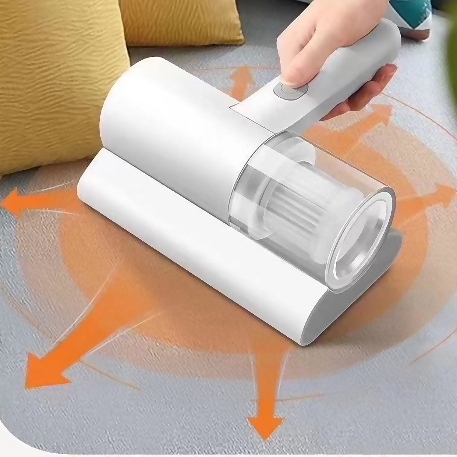 Un aspirapolvere portatile in azione. Un dispositivo bianco viene utilizzato su un tappeto, con frecce arancioni che indicano la direzione di aspirazione e un cuscino giallo.