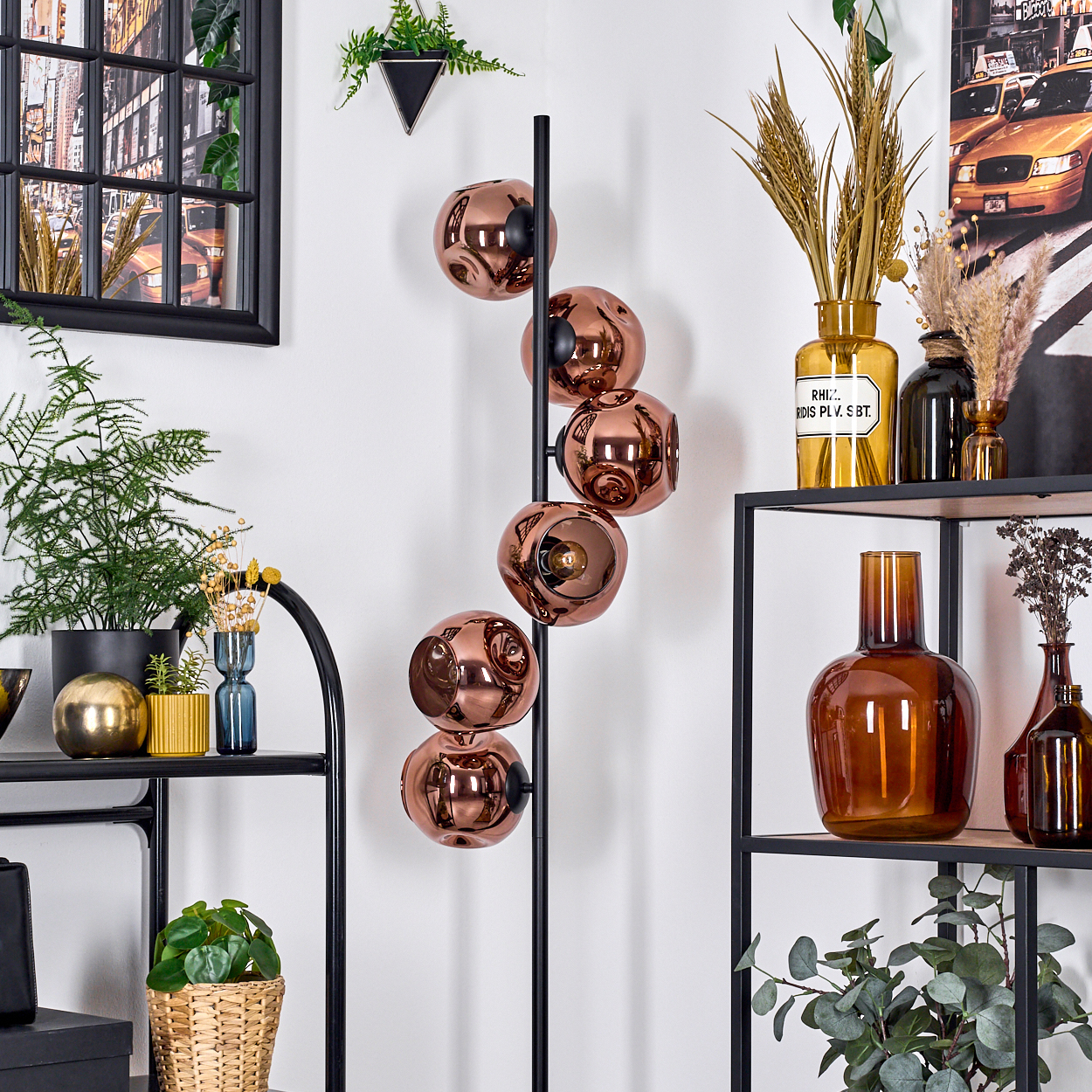 Modernes Interieur mit Kupferkugellampe, Pflanzen und Regalen mit Vasen. Der Hintergrund zeigt eine Stadtszene.