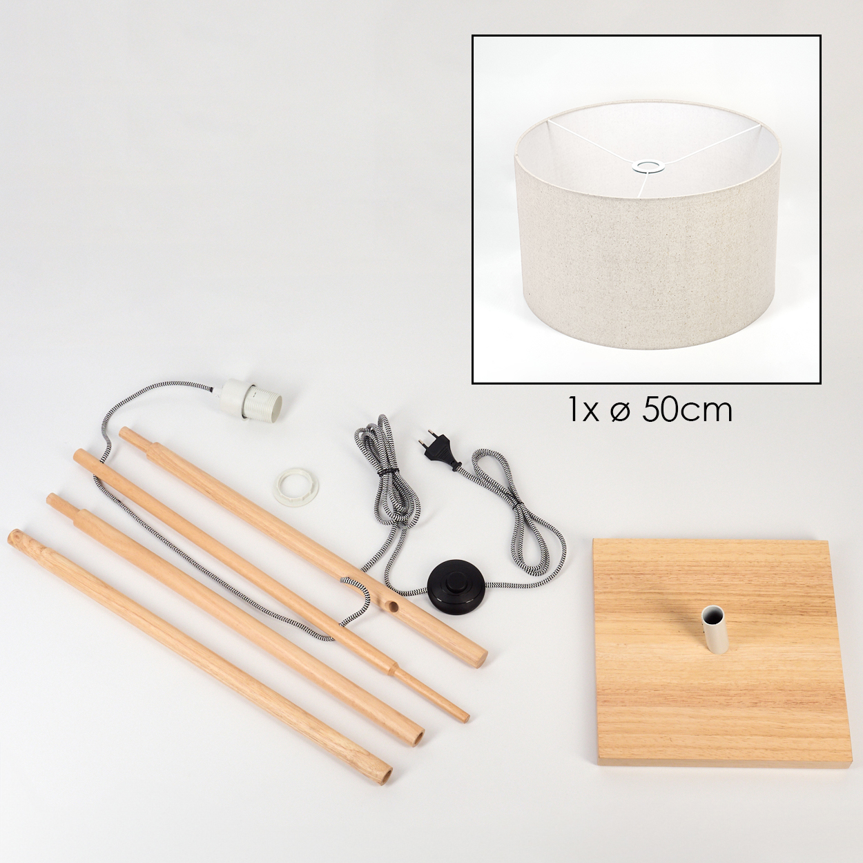 Eine zerlegte Lampe mit Holzstangen, einem Lampenschirm, elektrischen Komponenten und einem Holzsockel. Der Lampenschirm ist beige.