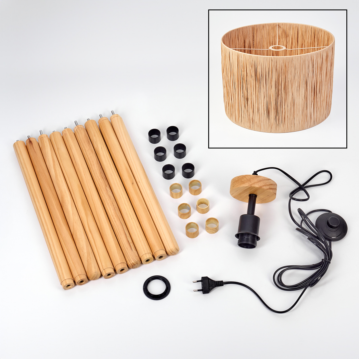 Eine zerlegte Lampe mit Holzbeinen, einem Lampenschirm und verschiedenen Teilen auf einer weißen Oberfläche. Der Lampenschirm ist oben rechts.