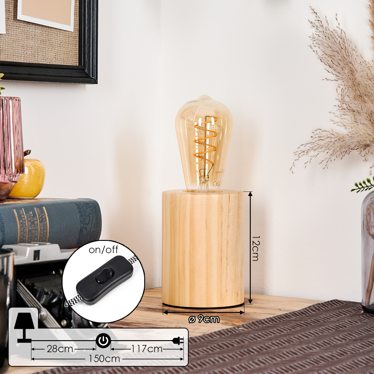 Eine Lampe mit Holzsockel und großer Glühbirne. Sie steht auf einem Holztisch mit Büchern und Dekorationen. Abmessungen werden angezeigt.