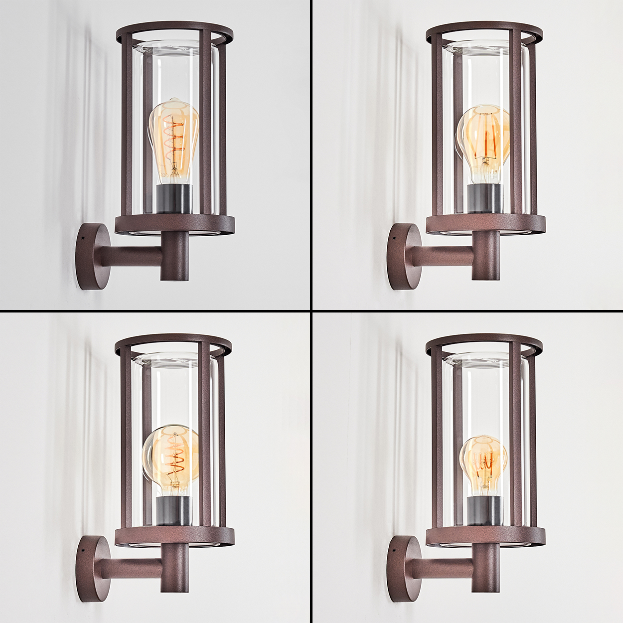 Vier Wandleuchten für den Außenbereich. Jede hat einen braunen Rahmen, einen Glaszylinder und eine Edison-Glühbirne. Lampen an weißer Wand.