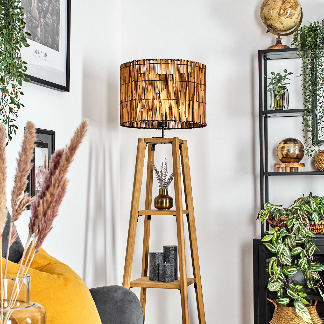 Raumecke mit Holzlampe, Regalen und Pflanzen. Globus und Deko-Artikel stehen auf den Regalen. Ein gelbes Kissen im Vordergrund.