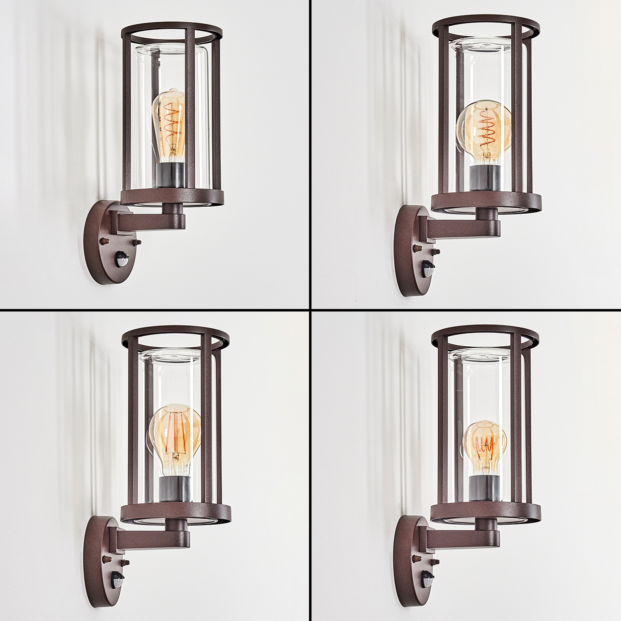 Vier Wandleuchten. Jede hat einen braunen Metallrahmen, einen Glaszylinder und eine warmtonige Glühbirne an einer weißen Wand.