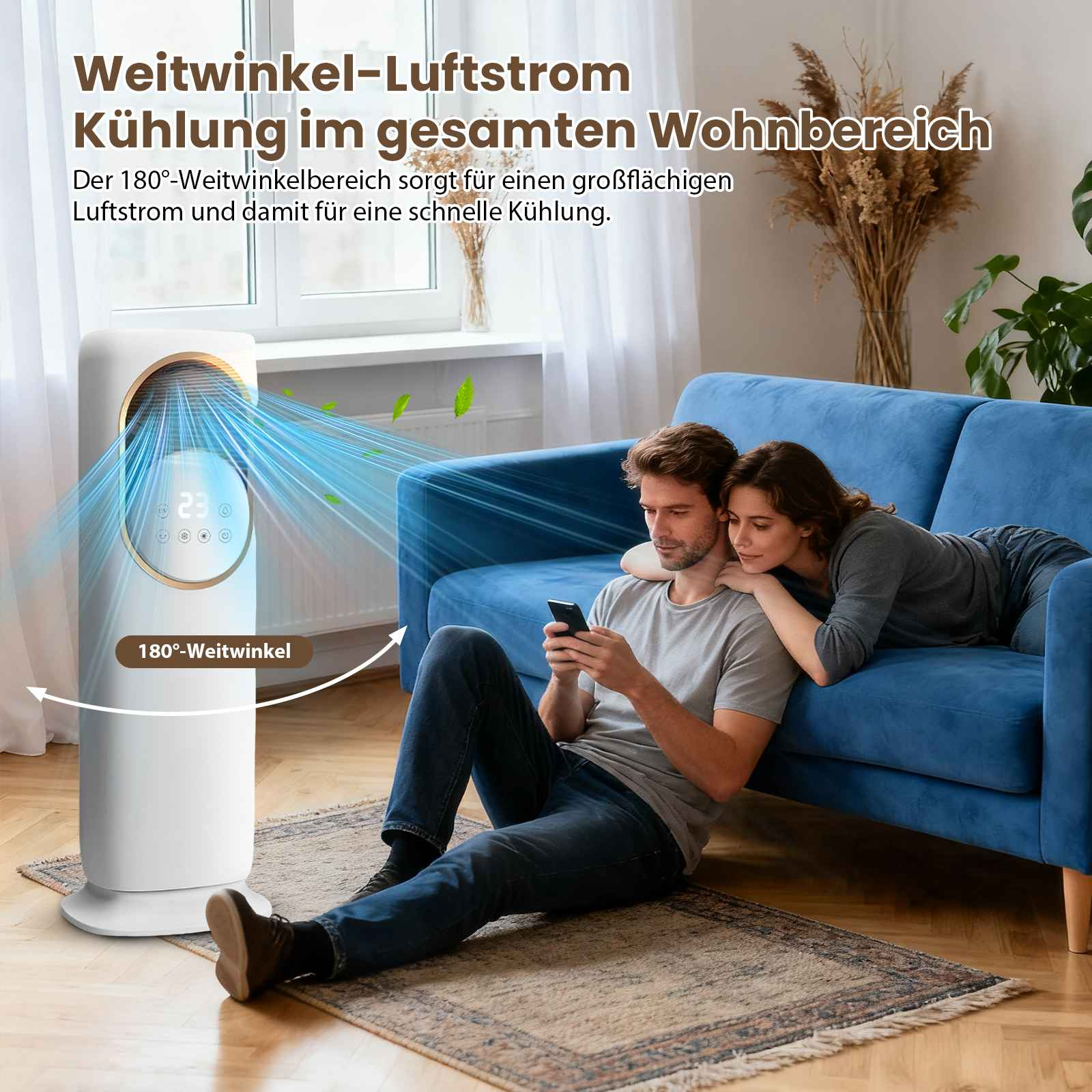 Ein Mann und eine Frau sitzen in der Nähe eines Ventilators, er benutzt ein Telefon. Blaue Couch im Hintergrund. Weißer Ventilator.