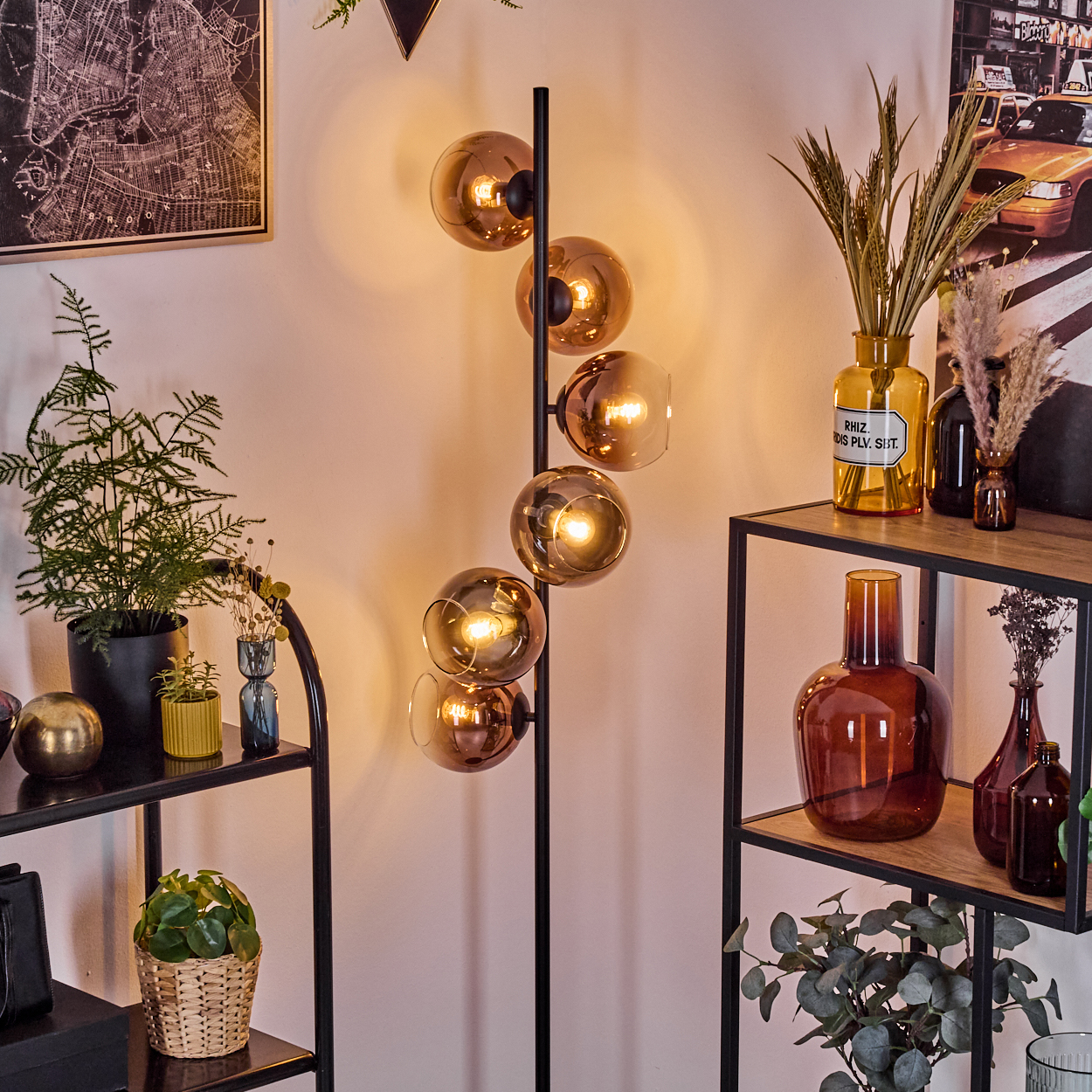 Ein modernes Wohnzimmer mit einer Stehlampe mit Glaskugeln. Regale mit Pflanzen und Vasen sind auf beiden Seiten.
