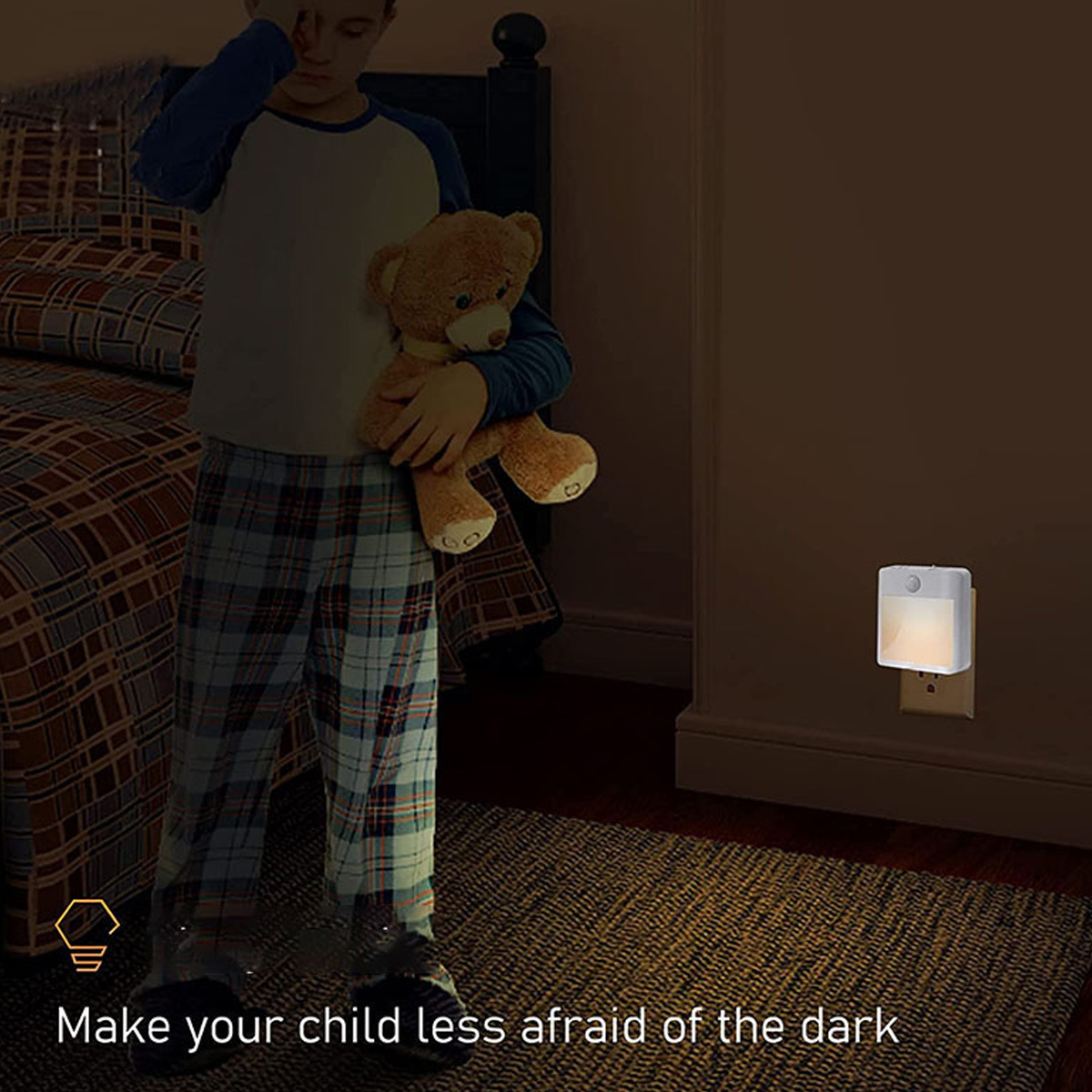 Ein Junge mit Teddybär in einem dunklen Raum. Ein Nachtlicht steckt in der Wand. Das Bett ist im Hintergrund.