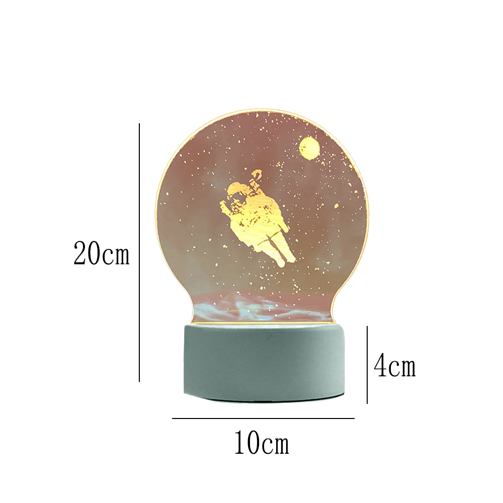 Eine dekorative Lampe mit Astronauten-Design in einer Glaskugel, auf einem grauen Sockel. Maße sind angegeben.