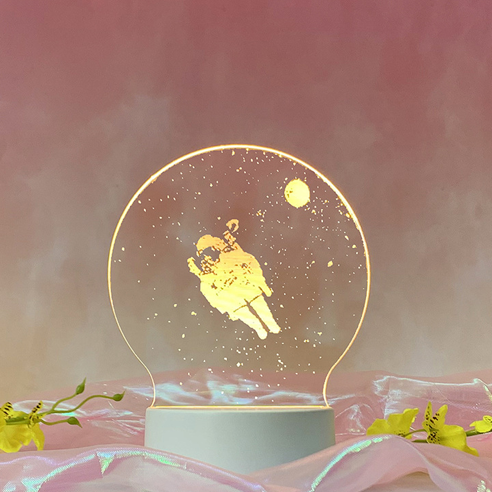Eine leuchtende Astronautenlampe. Das Bild zeigt einen Space-Man in einem transparenten Kreis. Der Hintergrund ist rosa mit einigen Blumen.