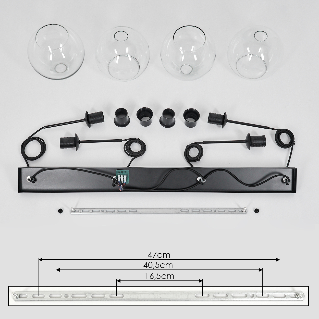Ein zerlegter Lampenbausatz: Glaskugeln, schwarze Lampenfassungen, eine rechteckige Basis und eine Metallschiene mit Maßen.