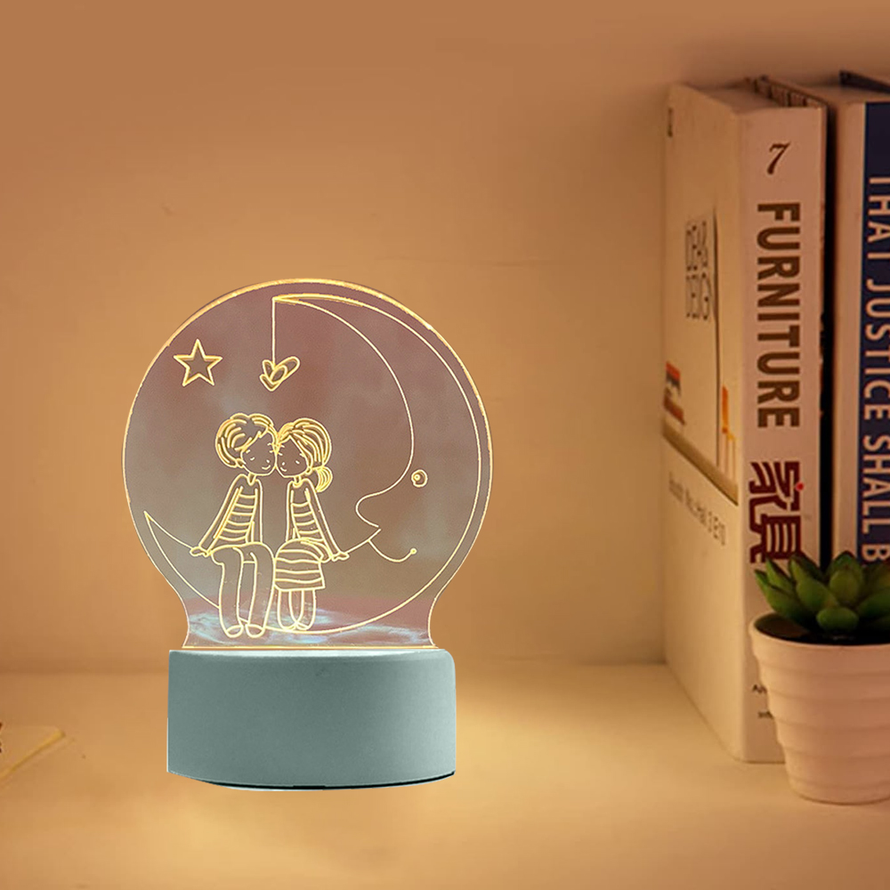 Ein Nachtlicht mit einem Paar auf einem Mond. Bücher und eine Pflanze stehen auf dem Regal. Das Licht hat einen blauen Sockel.